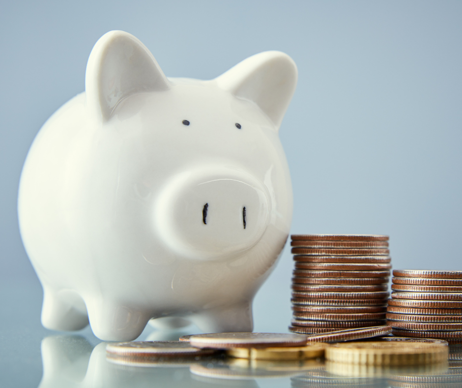 Ways to Save White piggy bank next to stack of quarters.