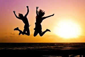 Two people jumping in the sunset.