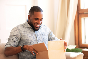 Man opening a box in his living room.